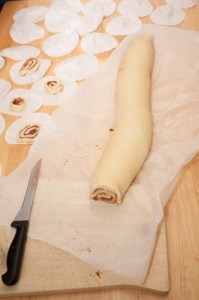 Cutting up the rolled up dough into cinnamon whirls