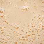 The frothy surface of whisked oil, eggs, and honey