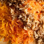 Adding grated carrots, orange zest, and chopped walnuts to the mixture for making Carrot, Walnut and Orange Cake