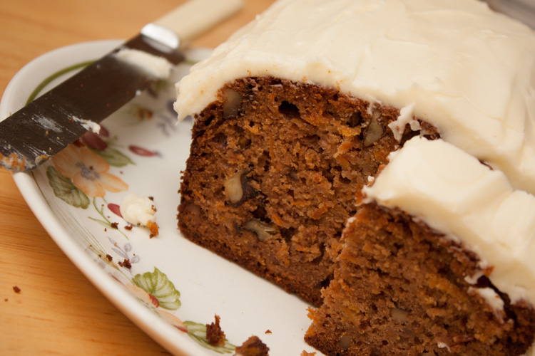 Carrot, Orange, and Walnut Sponge Cake cut, with half a slice on a plate.