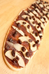 Rolled dough strip with cinnamon paste, apple, and raisins