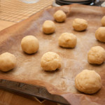 Grantham Gingerbread dough balls on a baking sheet ready for baking. The cookie dough balls are placed on a non-stick tray liner.